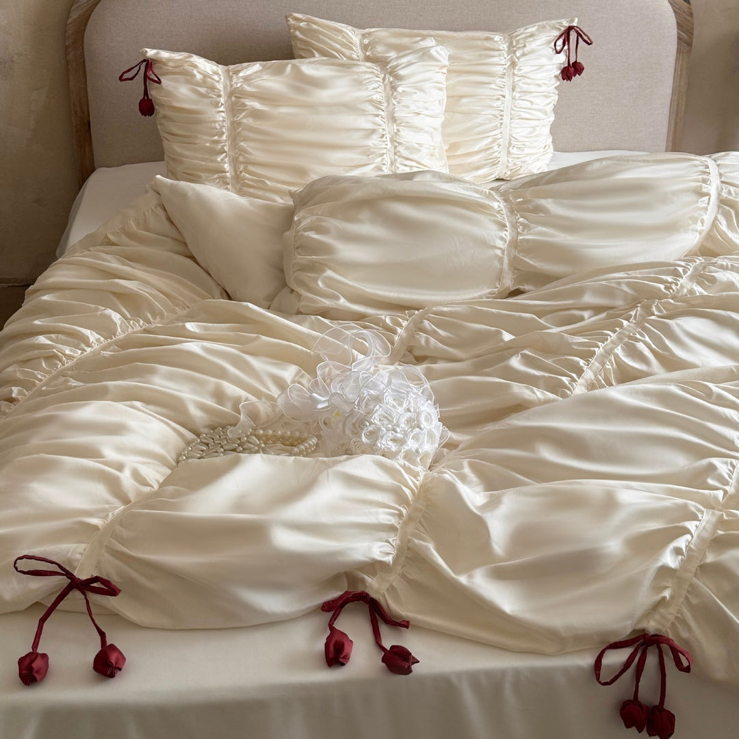 Satin bedding set with gathered drawstring look and tassels