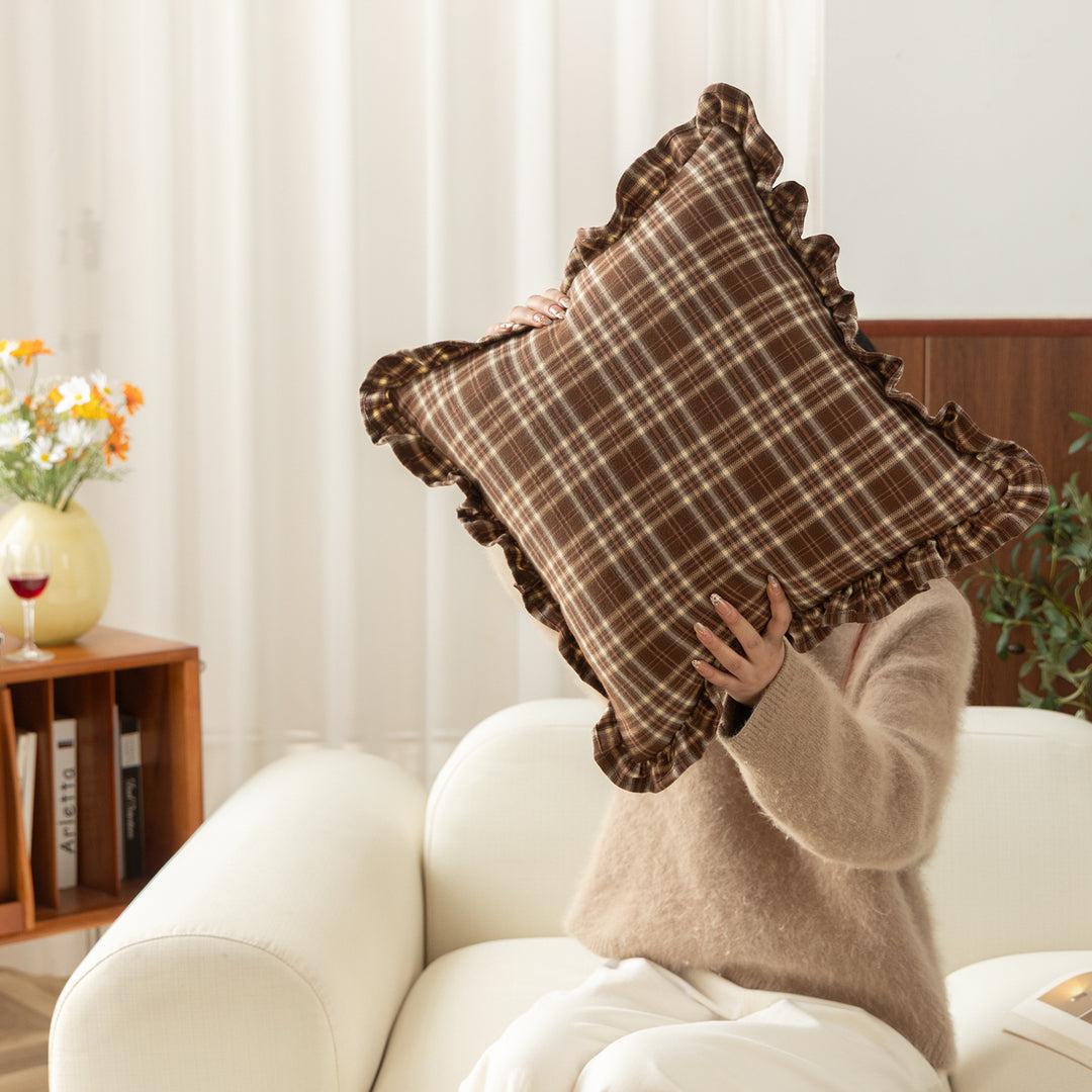 Decorative cushion with gingham pattern and playful ruffled edge
