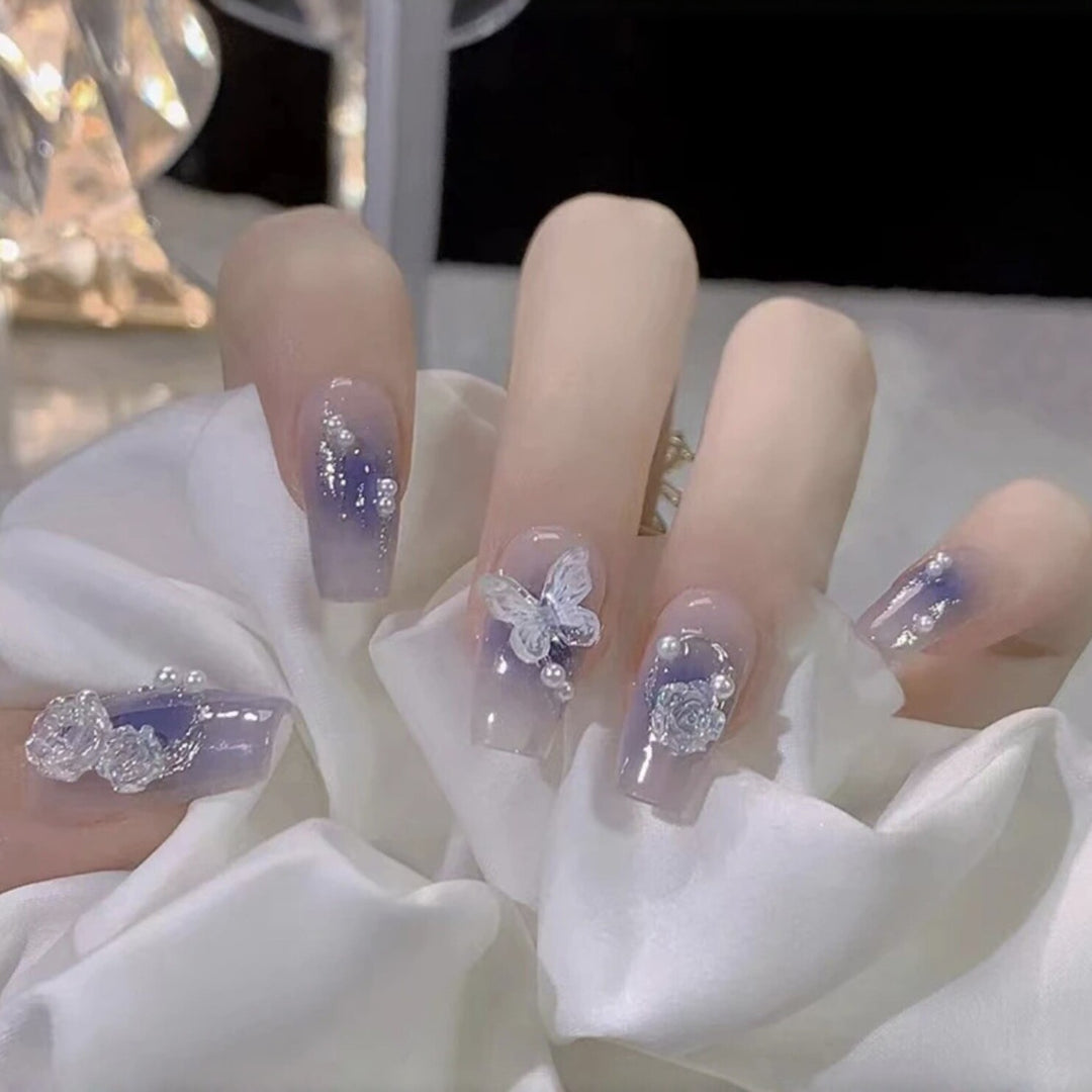 Artistic acrylic nails with butterfly design and glitter accents Kalsten