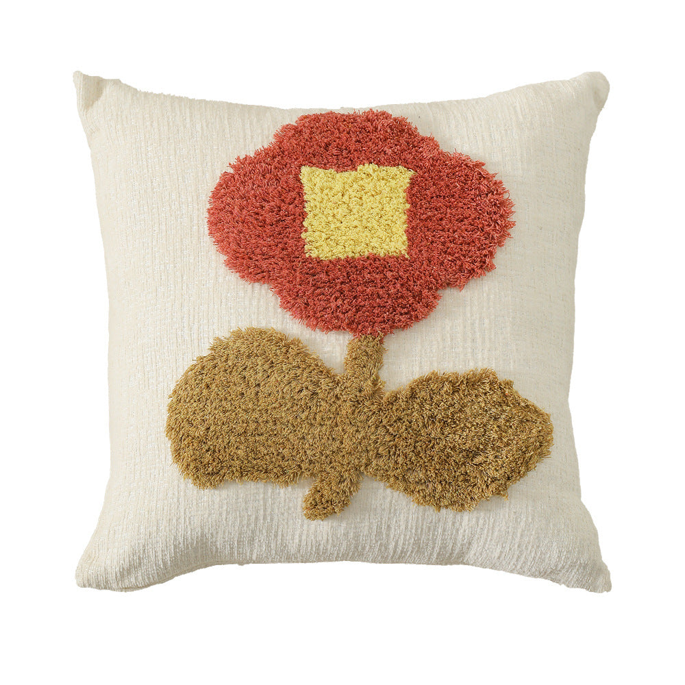 Square decorative pillow with hand-tufted floral appliqué and textured linen look