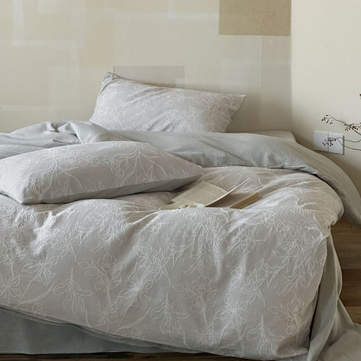 Finely woven cotton bedding set with embroidered floral relief and reversible cover