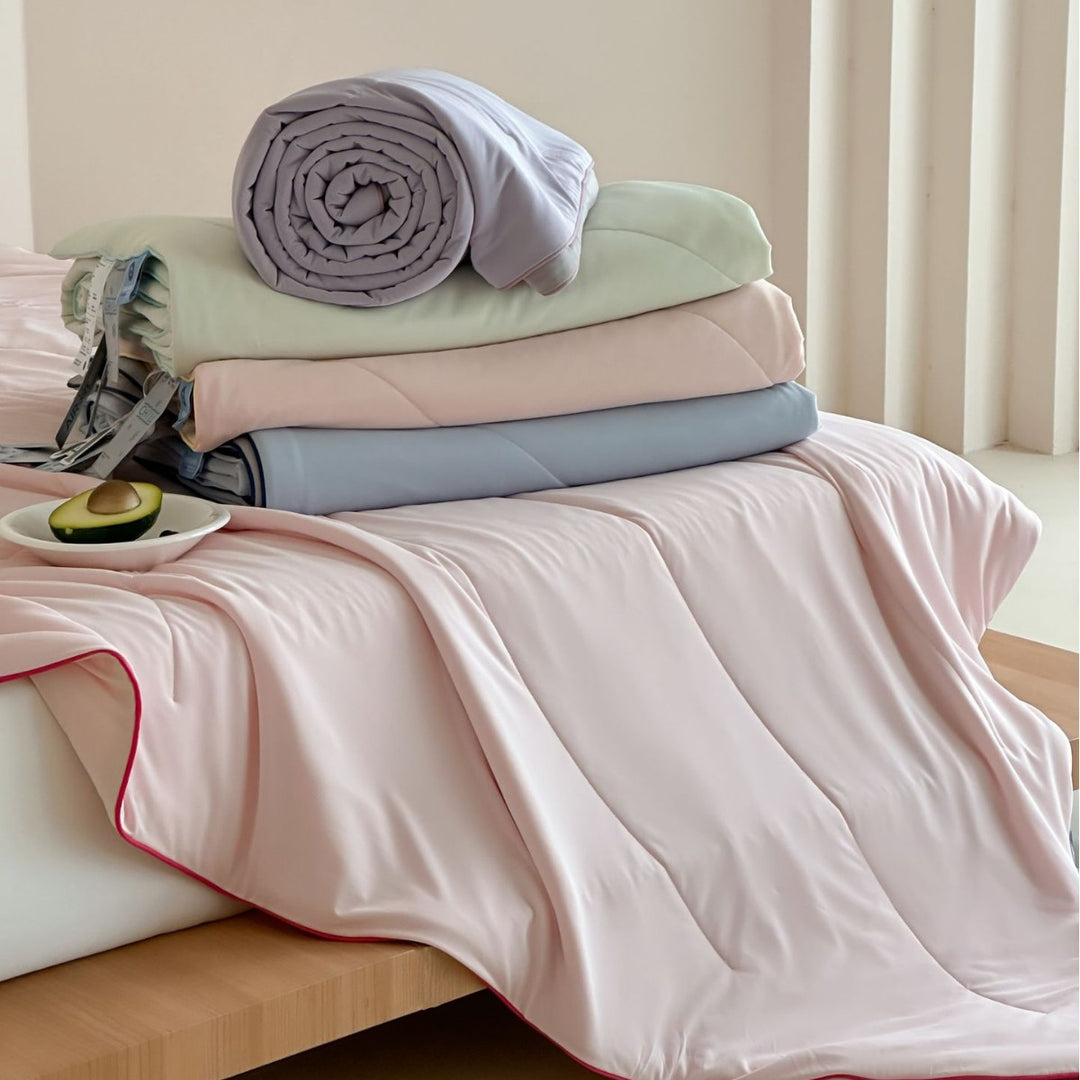 Elegant bedding set made of cotton satin with contrasting piping and light quilted blanket