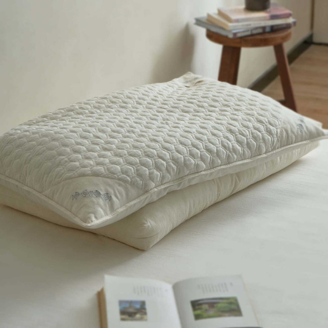 Ergonomic pillow with split filling of buckwheat shells and polyester fibers