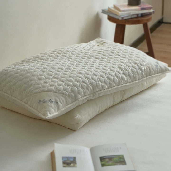 Ergonomic pillow with split filling of buckwheat shells and polyester fibers