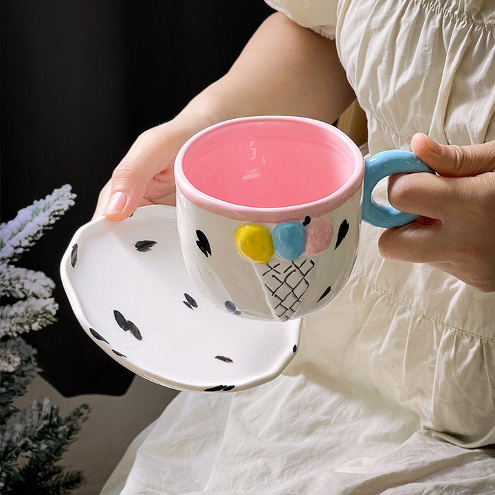 Playful handcrafted ceramic cup composition with saucer and pastel-colored round handle