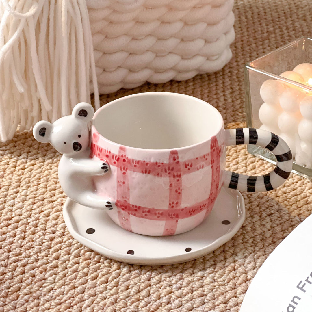 Playful ceramic cup set with koala relief handle and matching saucer
