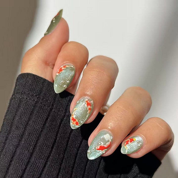 Artificial nail set with filigree koi fish designs and glitter accents Kalsten