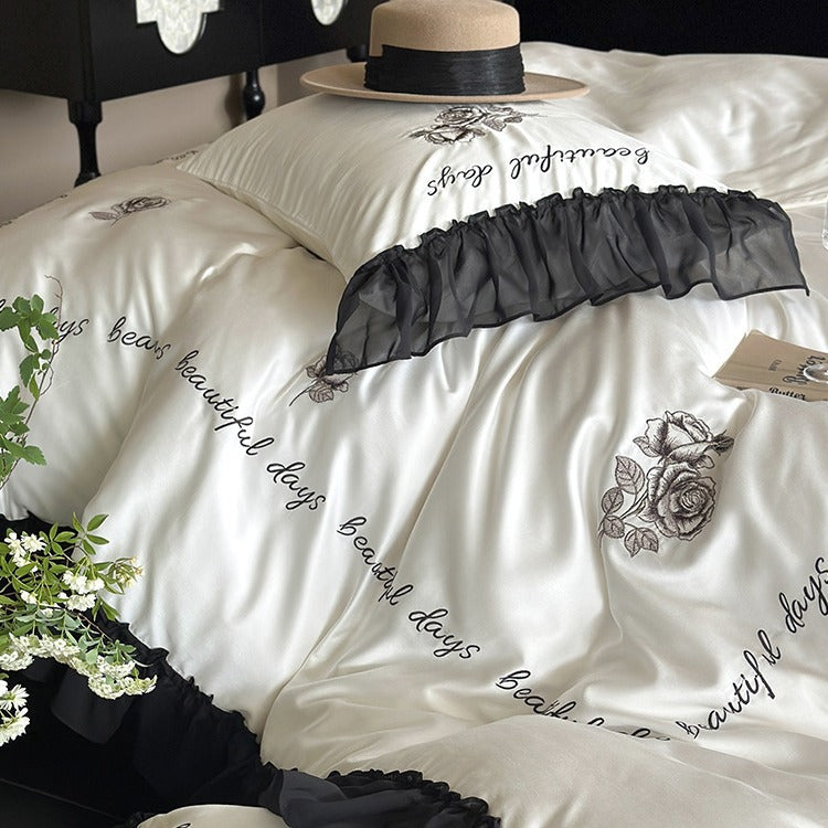 Bedding set made of silky-soft cotton satin with ruffle, delicate rose embroidery, and decorative lettering