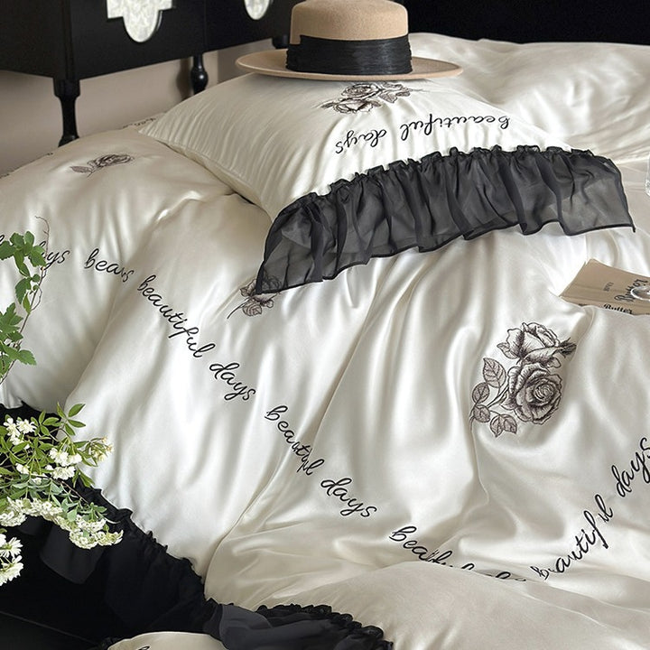 Bedding set made of silky-soft cotton satin with ruffle, delicate rose embroidery, and decorative lettering
