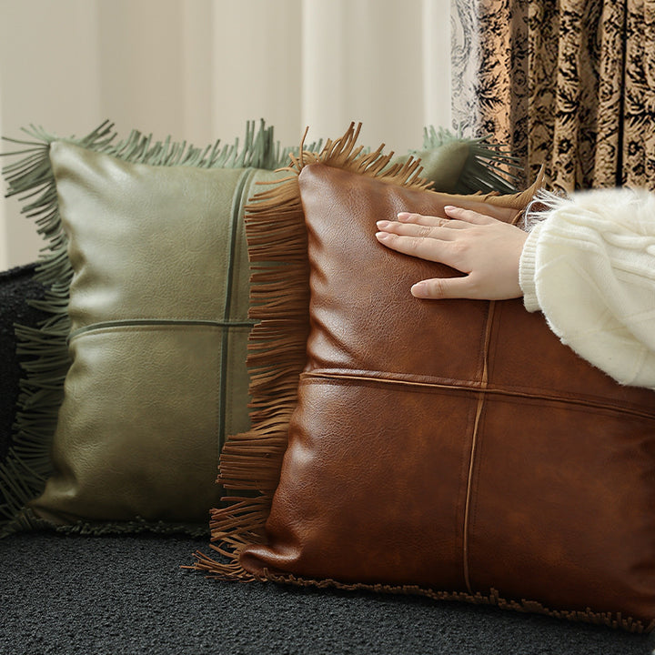 Decorative faux leather cushion with fringes and decorative seam