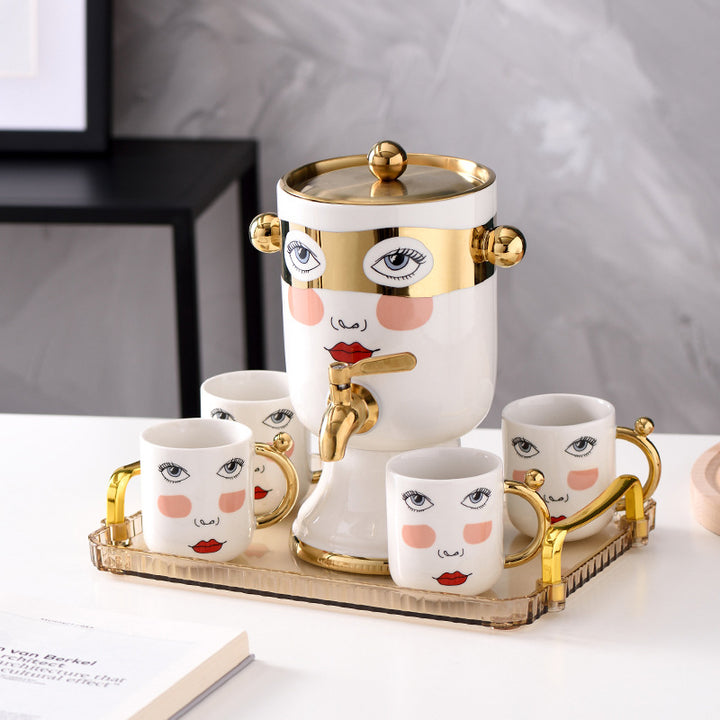 Decorative ceramic beverage dispenser with tap, hand-painted face and gold-finished lid