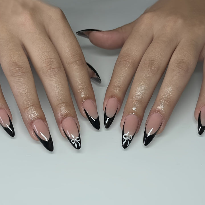 Acrylic nail set with elegant black and white design and cute bow accents Kalsten