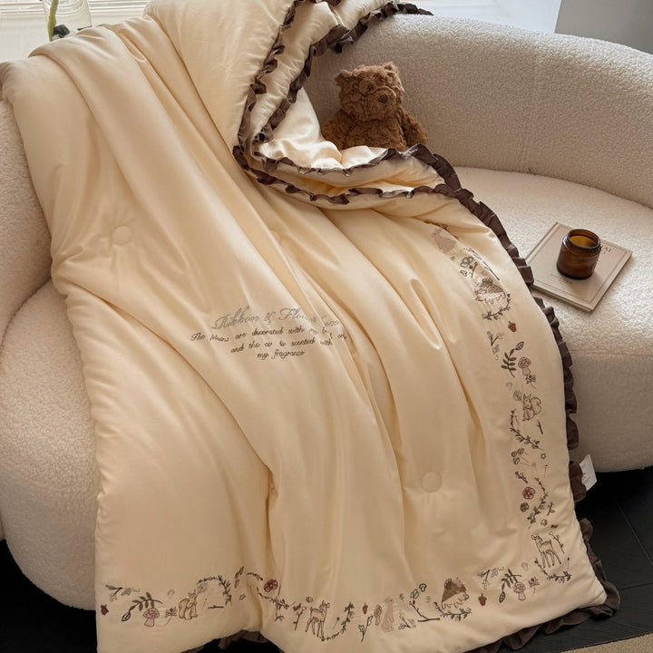 Quilted reversible duvet cover with floral embroidery and ruffled hem