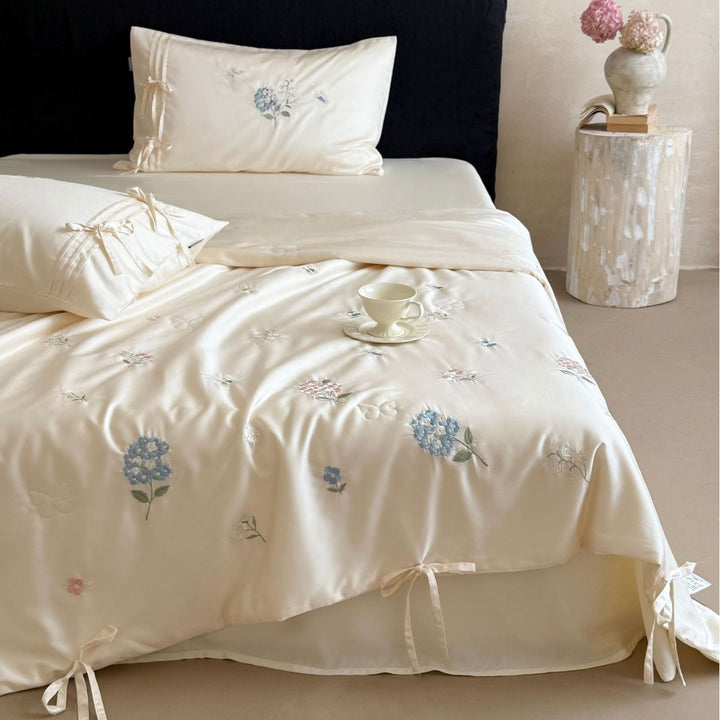 Satin bedding set with floral embroidery, tie ribbons, and silky glossy finish