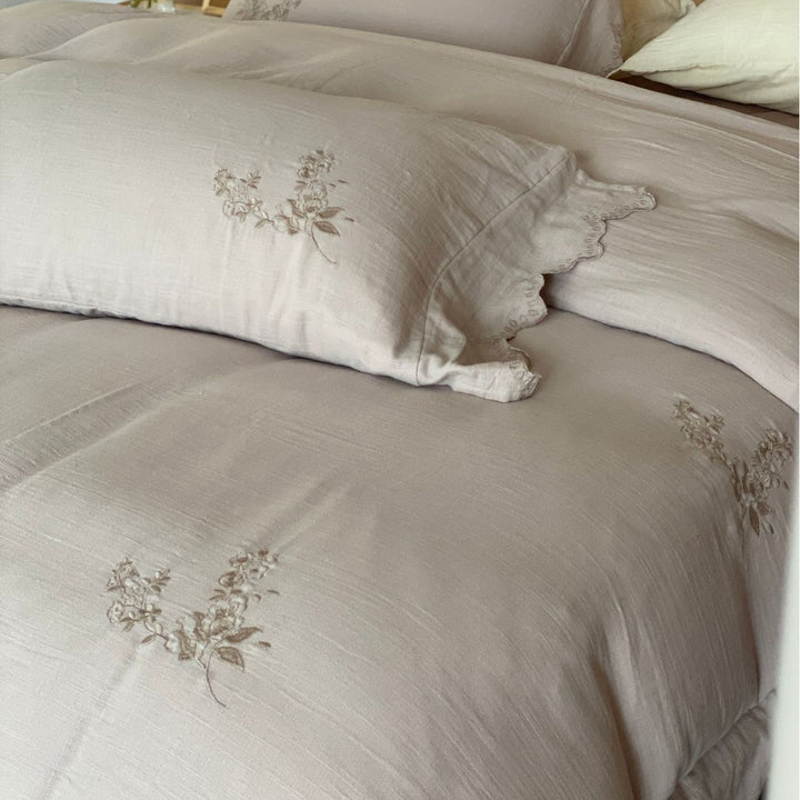 Linen look bedding set with floral embroidery and wavy hem
