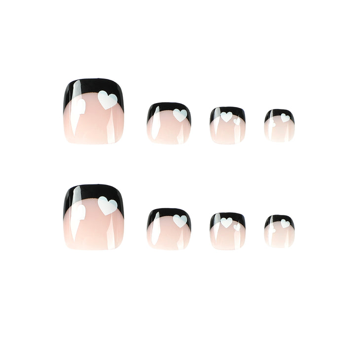 Artistic toenail design with heart motifs and modern black-and-white design Kalsten
