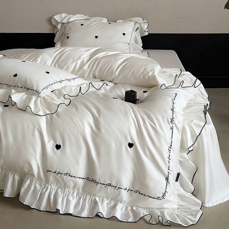 Luxurious cotton satin bedding set with ruffled trim, embroidered heart motifs, and calligraphic writing
