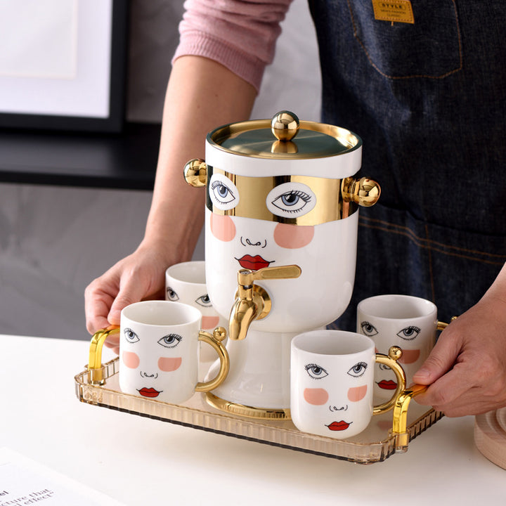 Decorative ceramic beverage dispenser with tap, hand-painted face and gold-finished lid