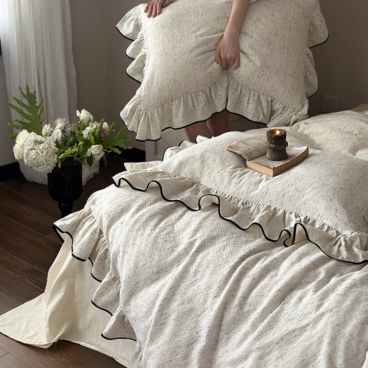 Playful ruffle bedding set in linen look with contrasting piping and soft wash