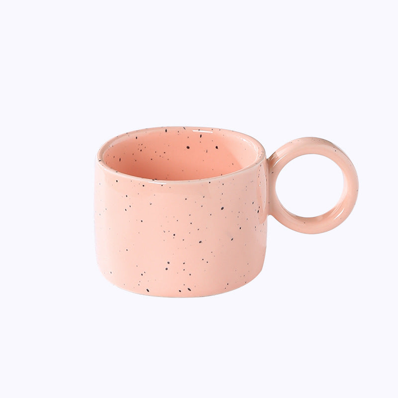 Ceramic mug with heart-shaped handle and speckle design