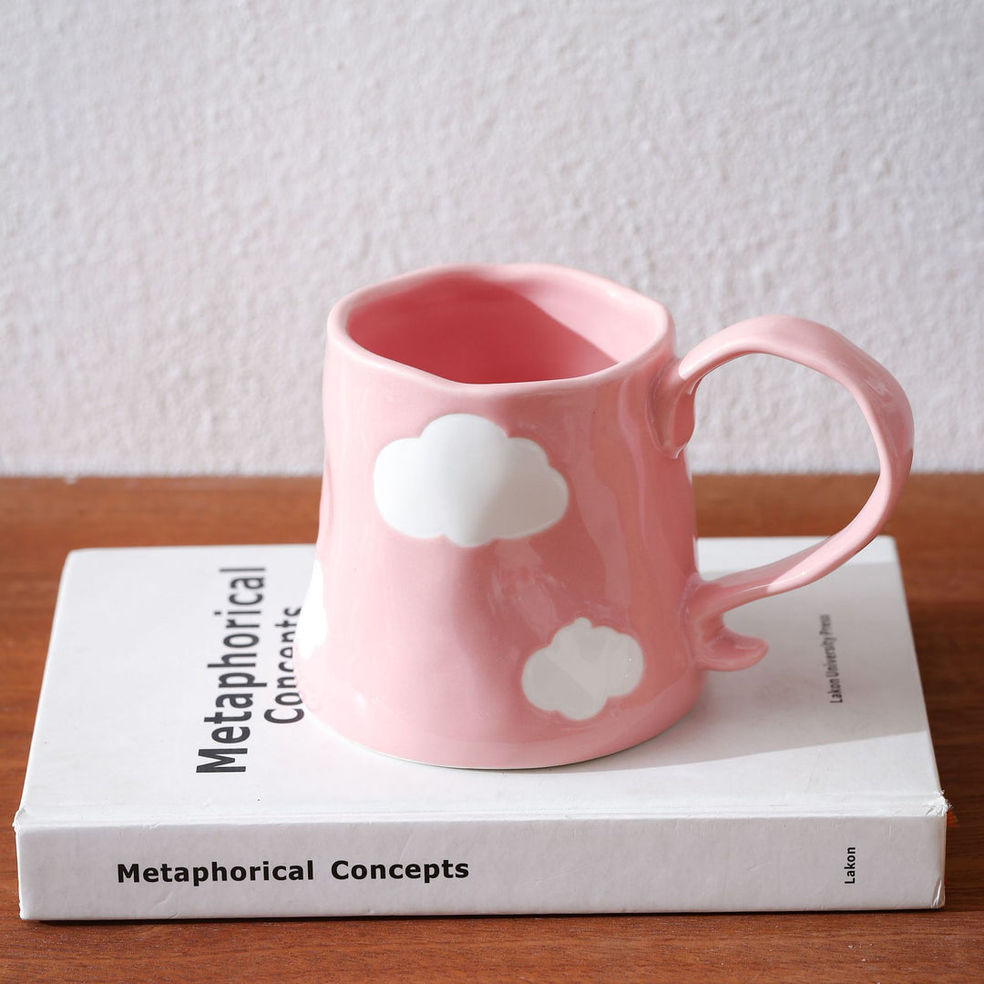 Hand-shaped ceramic mug with cloud relief and organic edge