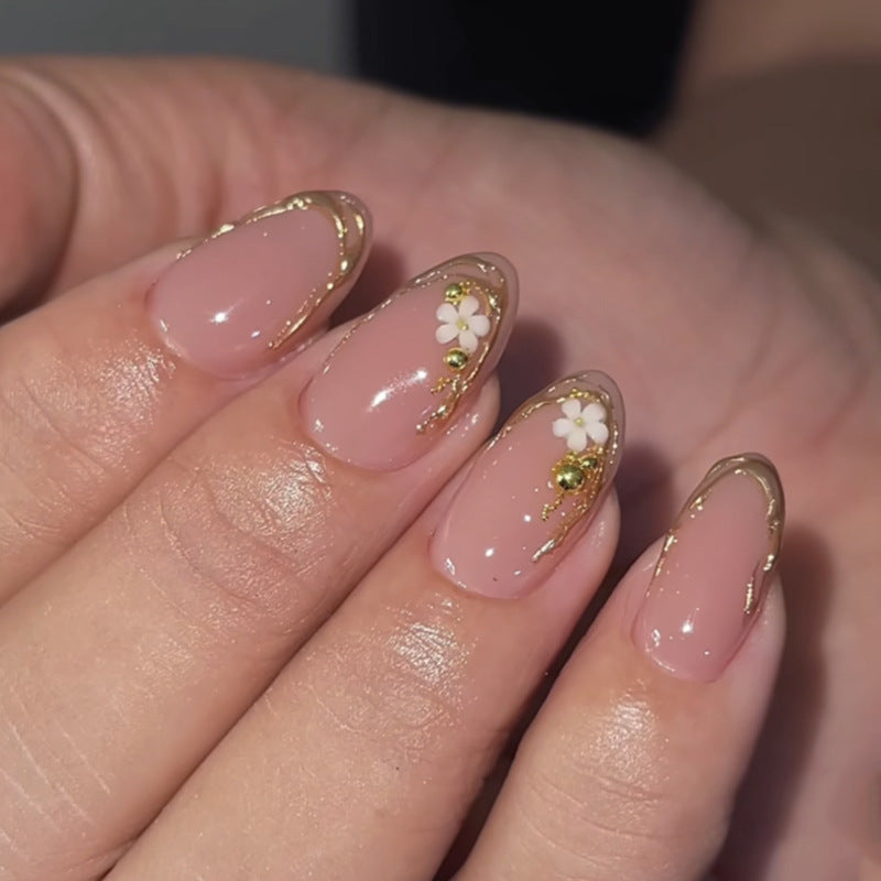 Artful nail design with golden accents and floral details Kalsten