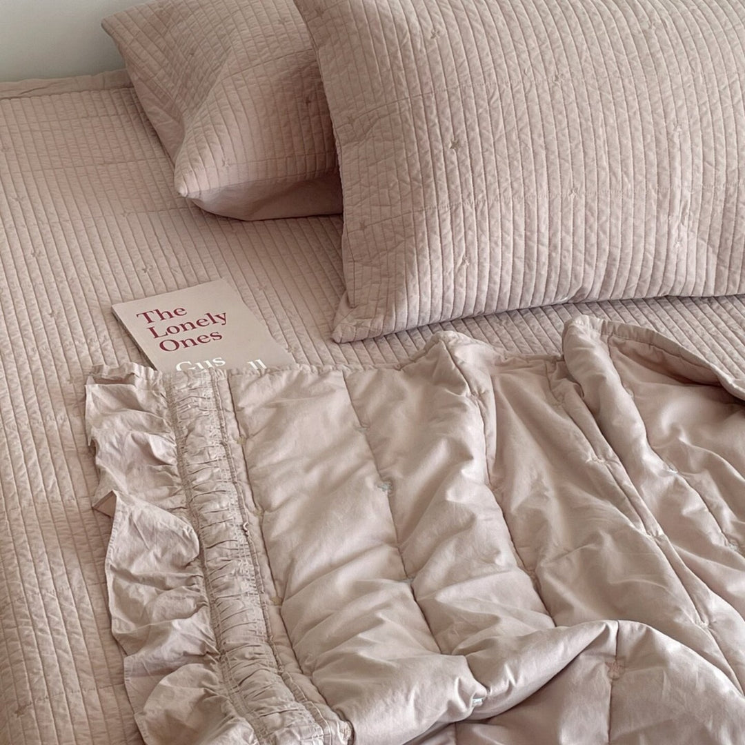 Quilted bedspread with delicate longitudinal stitching and matching pillowcases