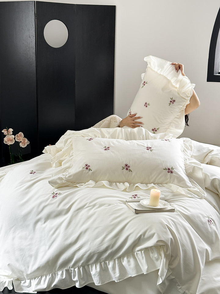 Elegant bed linen set made of breathable cotton satin with delicate floral embroidery and ruffled hem