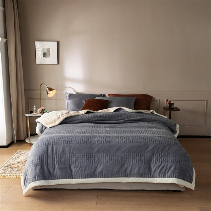 Reversible quilted comforter with structured box stitching and cotton trim