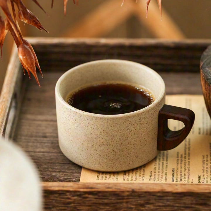 Ceramic mug with ergonomic wooden handle and matching coaster