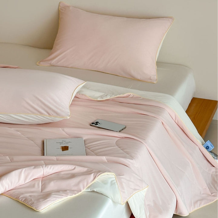 Elegant bedding set made of cotton satin with contrasting piping and light quilted blanket