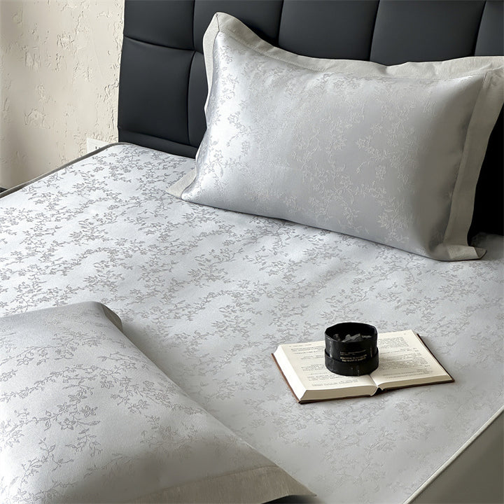 Finely woven satin fitted sheet with floral jacquard relief and reinforced all-round elastic