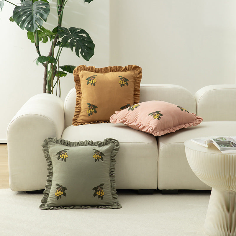 Square decorative pillow with ruffled edges and hand-stitched flower appliqués