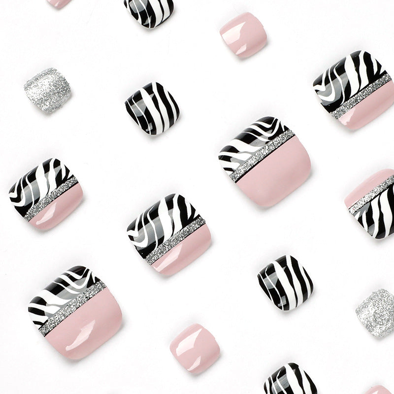 Artistic toenail art with zebra pattern and glitter accents Kalsten