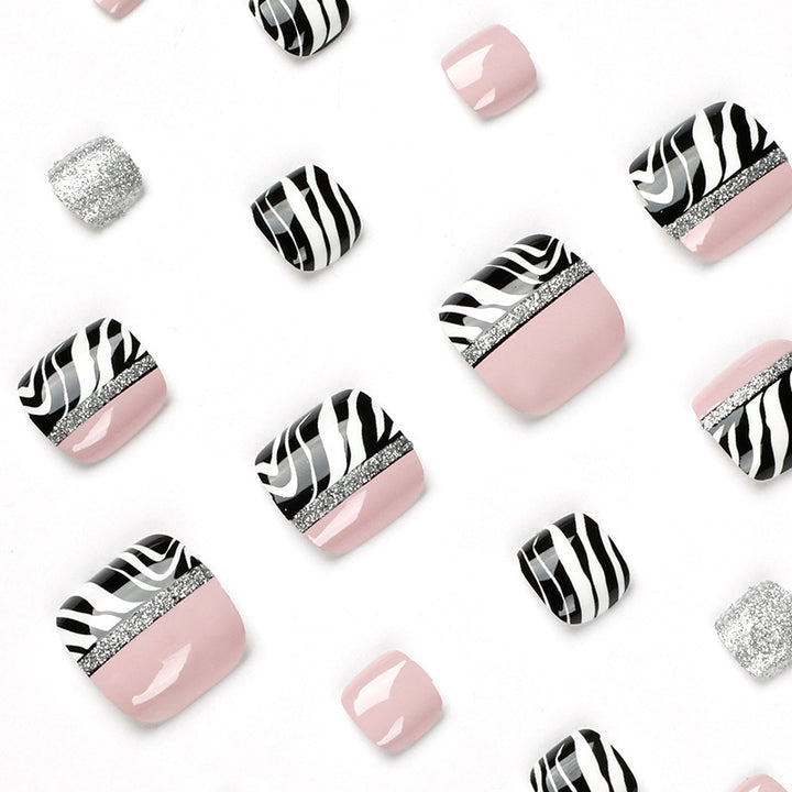 Artistic toenail art with zebra pattern and glitter accents Kalsten