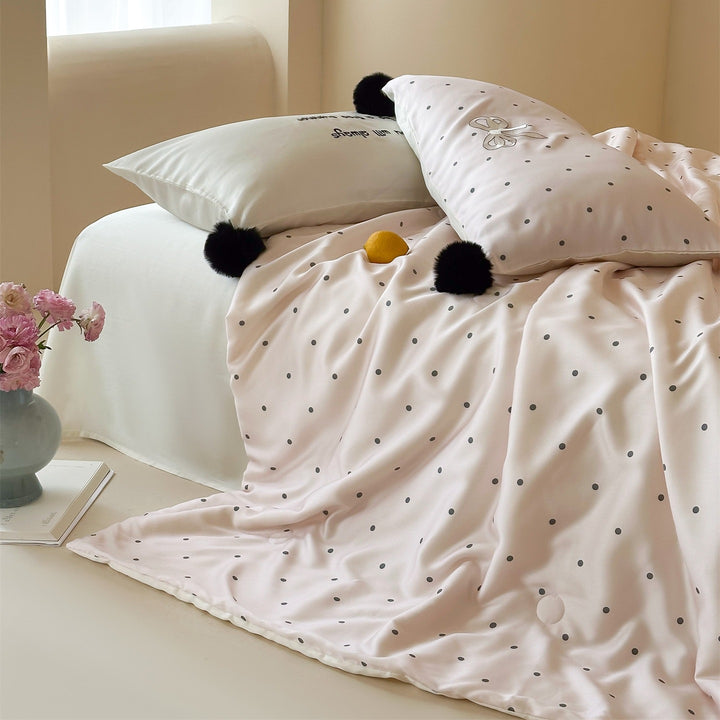 Luxurious satin bedding set with polka dot pattern and pom-pom tassels