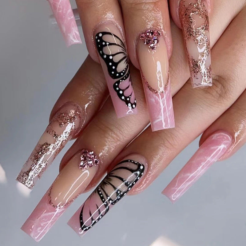 Glamorous nail extensions with beautiful butterfly motifs and glitter accents Kalsten