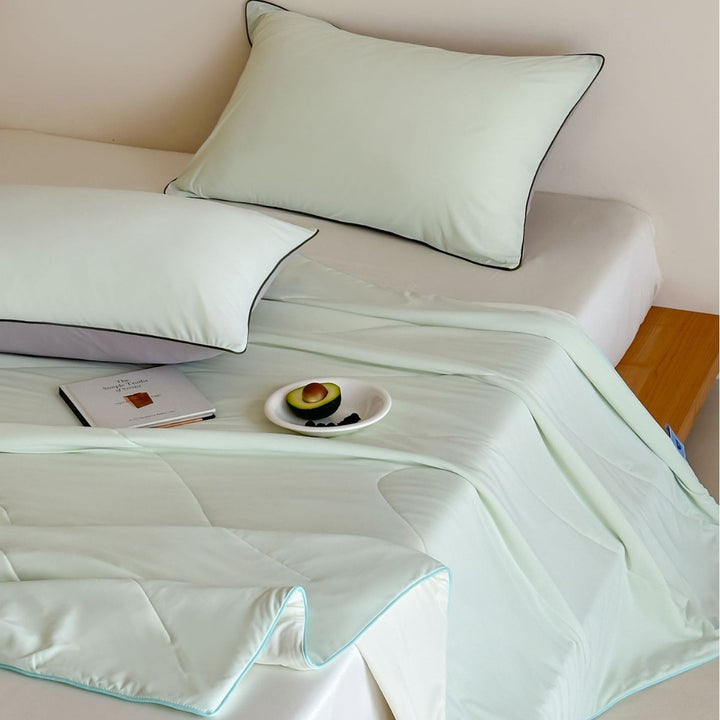 Elegant bedding set made of cotton satin with contrasting piping and light quilted blanket