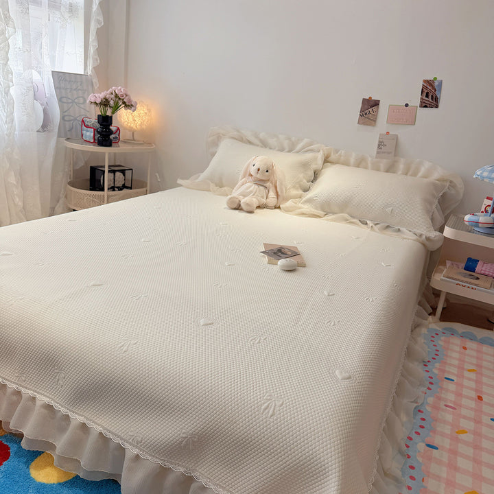 Quilted bedspread with ruffle and delicate floral quilting