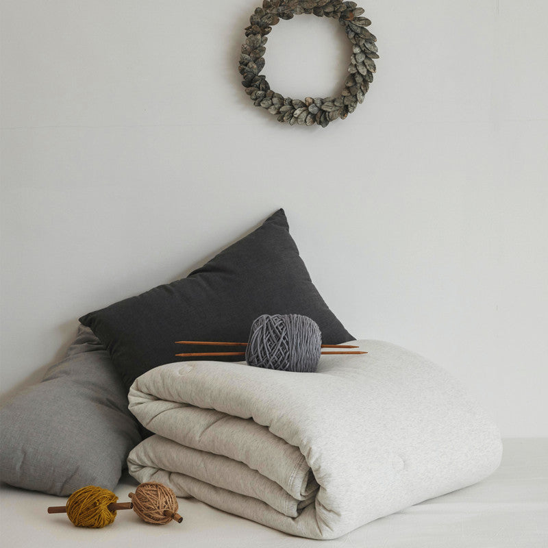 Ultralight climate-regulating quilted blanket with compact filling and cotton surface