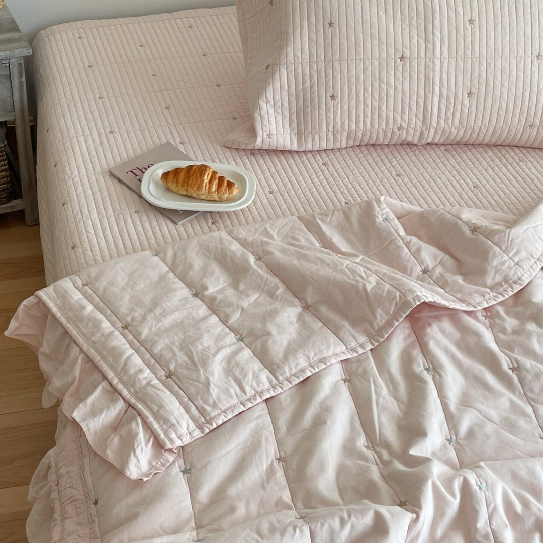 Quilted bedspread with delicate longitudinal stitching and matching pillowcases