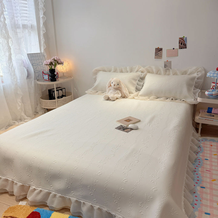 Quilted bedspread with ruffle and delicate floral quilting
