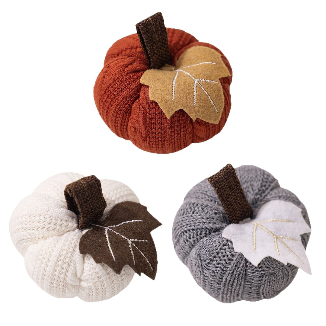 Knitted fabric pumpkin as autumn table decoration with felt leaf