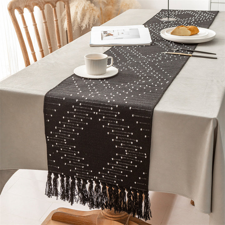 Woven table runner with geometric polka dot pattern, hand-fringed edge and sturdy cotton blend
