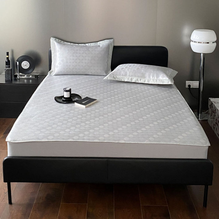 Quilted mattress topper with jacquard pattern and non-slip base