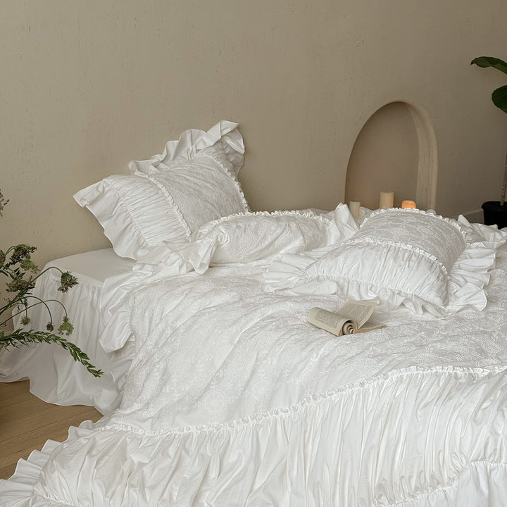Romantic broderie anglaise bedding set with ruffle, quilted bedspread and decorative cushion