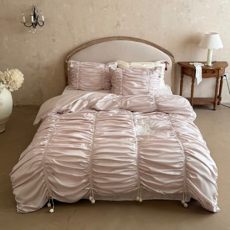Satin bedding set with gathered drawstring look and tassels