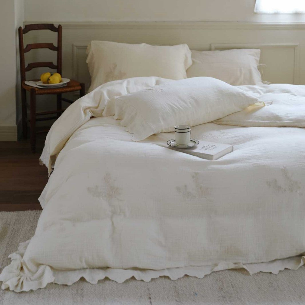 Linen look bedding set with floral embroidery and wavy hem
