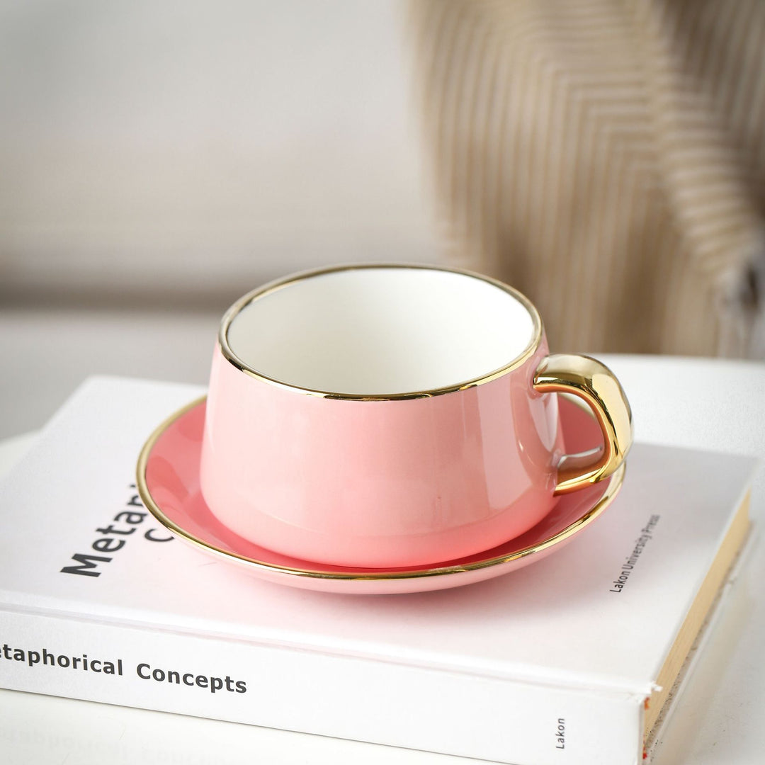 Elegant porcelain cup with saucer and sculptural gold handle