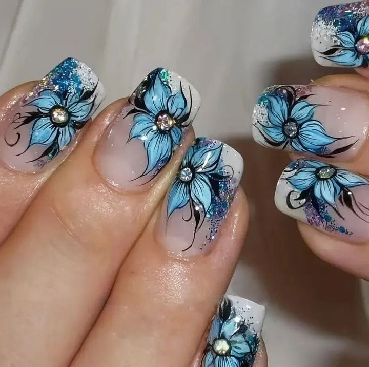 Artificial nail set with intricate floral designs and glitter elements Kalsten